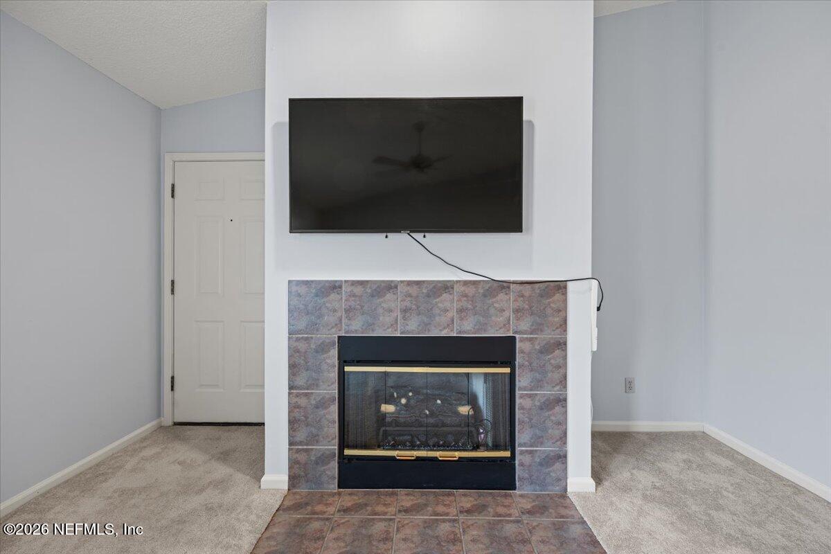 106 Ponte Vedra Colony Circle Ponte Vedra Beach, FL 32082 - Photo 12 of 30 a living room with a fireplace and a flat screen tv