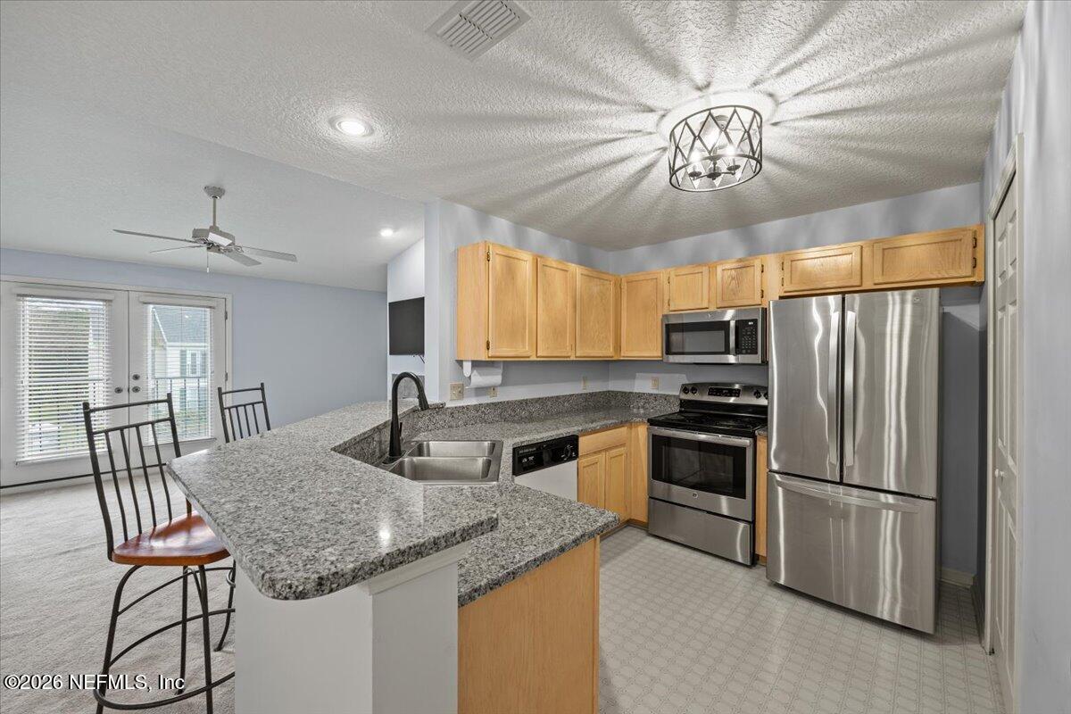 106 Ponte Vedra Colony Circle Ponte Vedra Beach, FL 32082 - Photo 13 of 30 a kitchen with stainless steel appliances granite countertop a sink a stove a refrigerator cabinets and dining table
