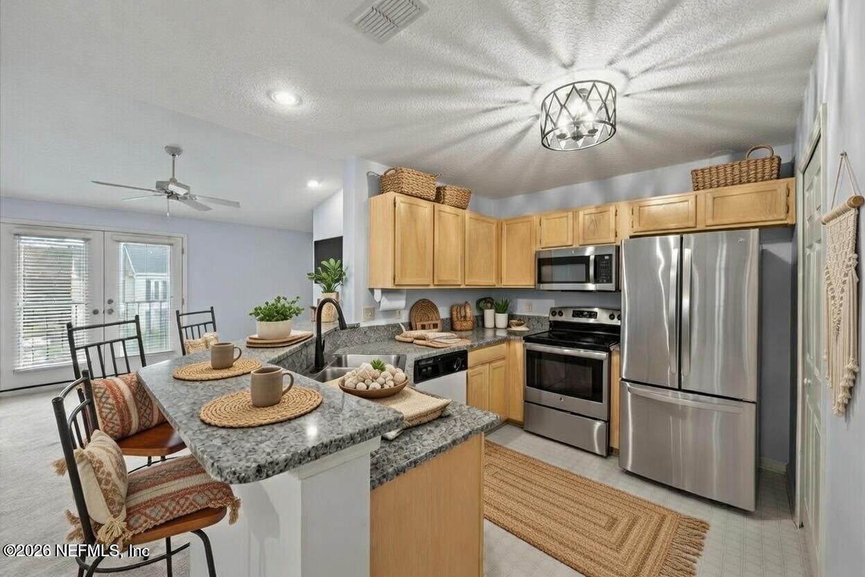 106 Ponte Vedra Colony Circle Ponte Vedra Beach, FL 32082 - Photo 14 of 30 a kitchen with a refrigerator a stove a dining table and chairs with wooden floor