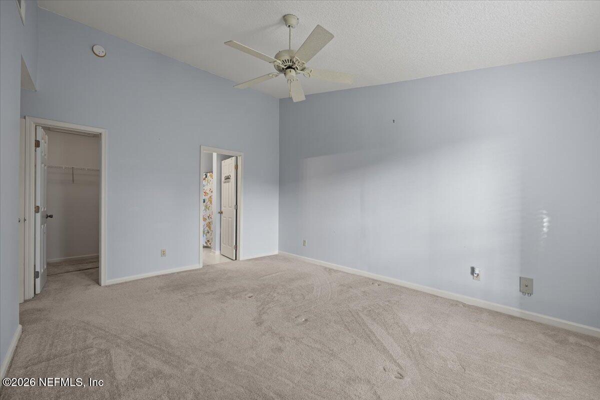 106 Ponte Vedra Colony Circle Ponte Vedra Beach, FL 32082 - Photo 19 of 30 an empty room with chandelier fan and windows