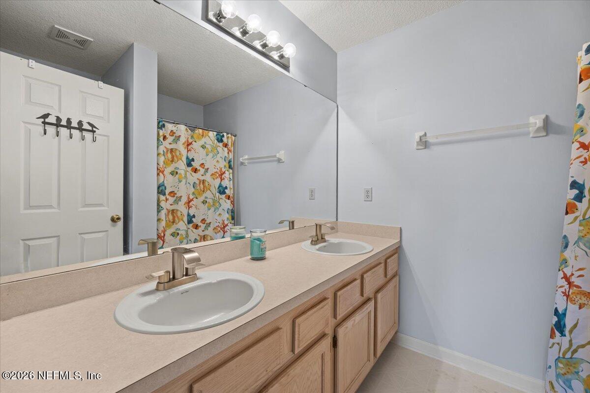 106 Ponte Vedra Colony Circle Ponte Vedra Beach, FL 32082 - Photo 23 of 30 a bathroom with a double vanity sink and a mirror