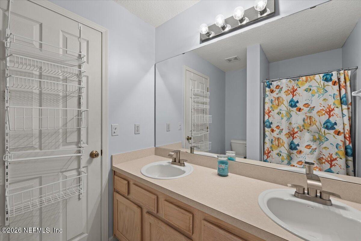 106 Ponte Vedra Colony Circle Ponte Vedra Beach, FL 32082 - Photo 24 of 30 a bathroom with a double vanity sink a mirror and shower