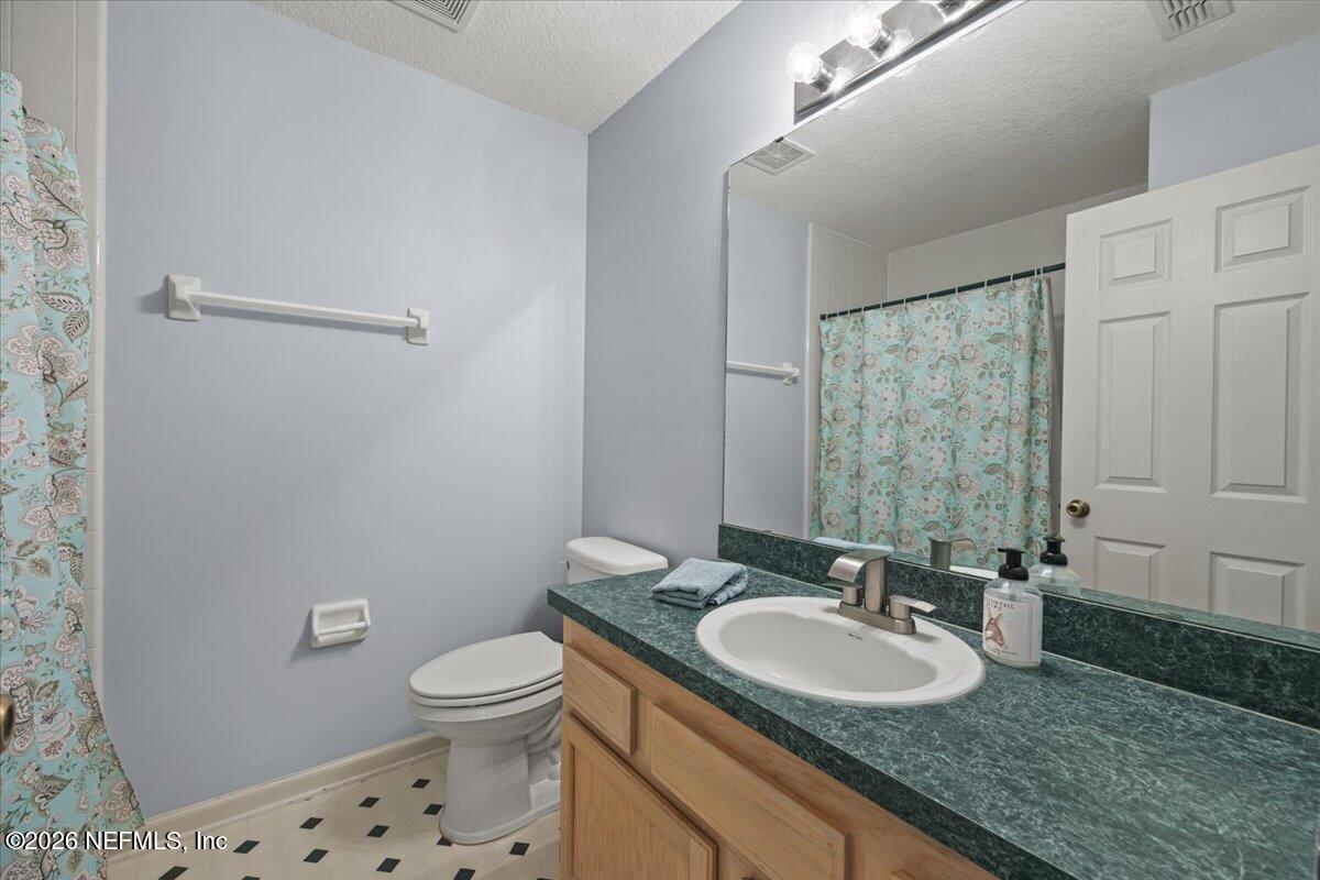 106 Ponte Vedra Colony Circle Ponte Vedra Beach, FL 32082 - Photo 28 of 30 a bathroom with a granite countertop sink a toilet and a mirror