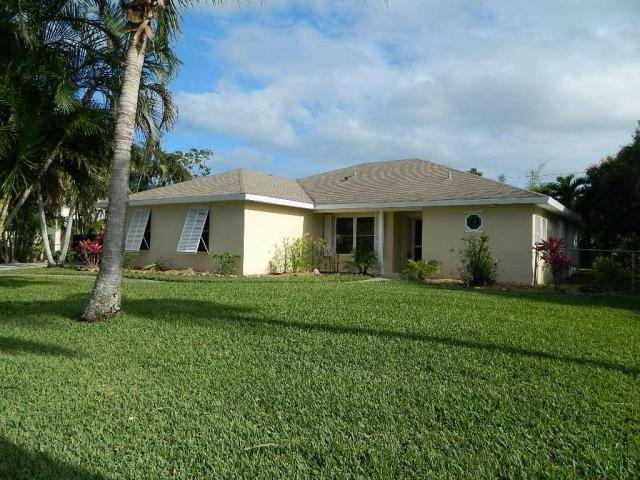 5702 Southeast Hull Street Stuart, FL 34997 - Photo 1 of 12 a front view of a house with a garden