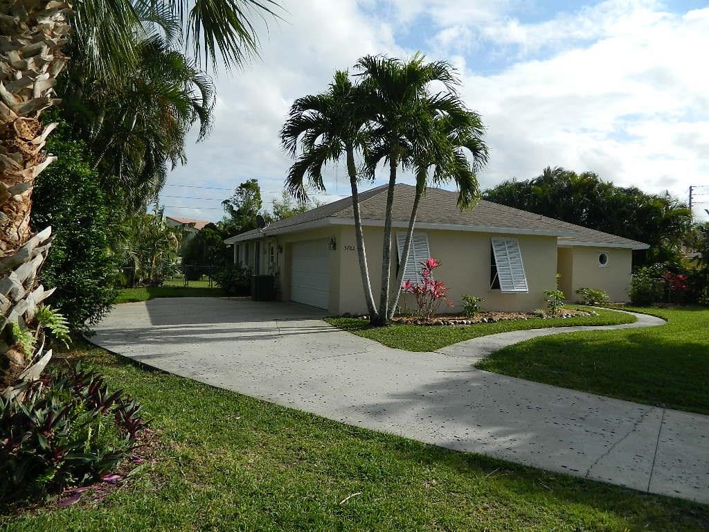5702 Southeast Hull Street Stuart, FL 34997 - Photo 2 of 12 a front view of a house with garden