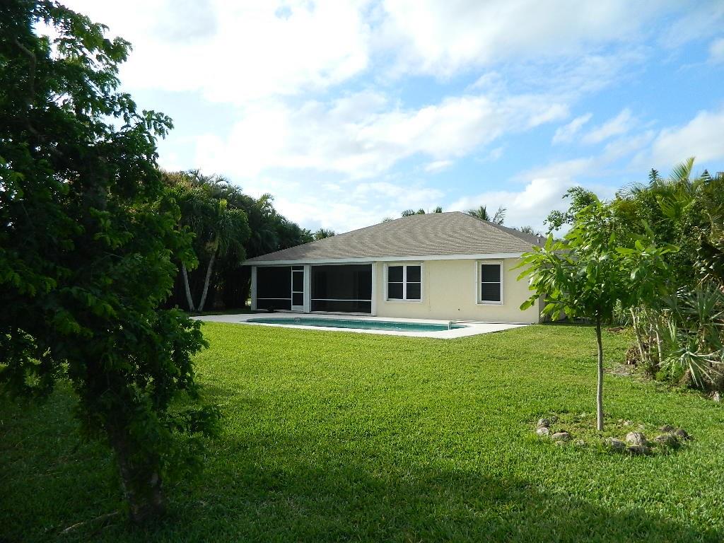 5702 Southeast Hull Street Stuart, FL 34997 - Photo 4 of 12 a front view of a house with garden