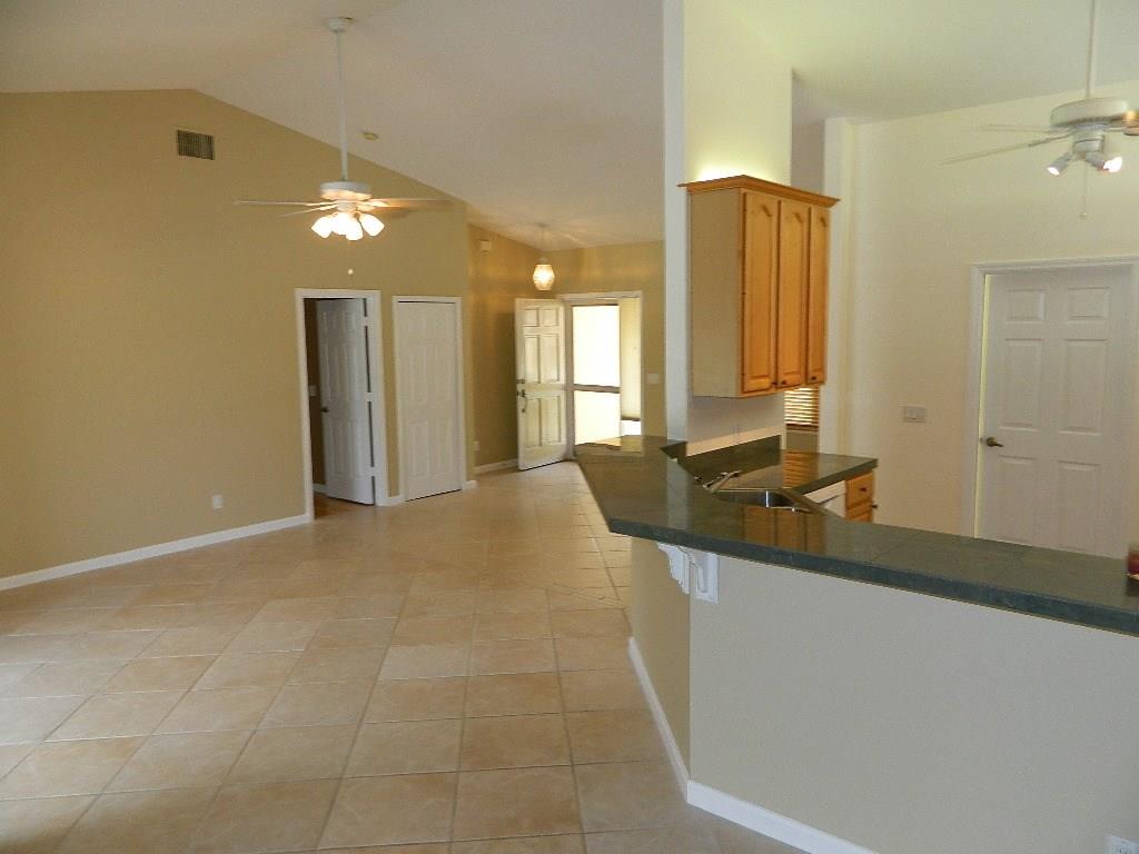 5702 Southeast Hull Street Stuart, FL 34997 - Photo 7 of 12 a bathroom with a granite countertop sink a mirror and a shower