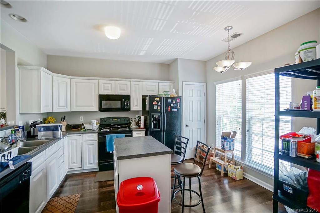 10225 Garrett Grigg Road Charlotte, NC 28262 - Photo 12 of 30 a kitchen with granite countertop a stove top oven a sink dishwasher and white cabinets with wooden floor