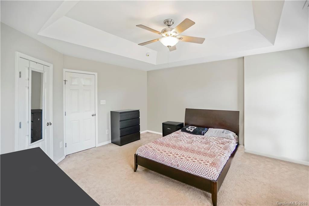10225 Garrett Grigg Road Charlotte, NC 28262 - Photo 18 of 30 a bedroom with a bed and a chandelier