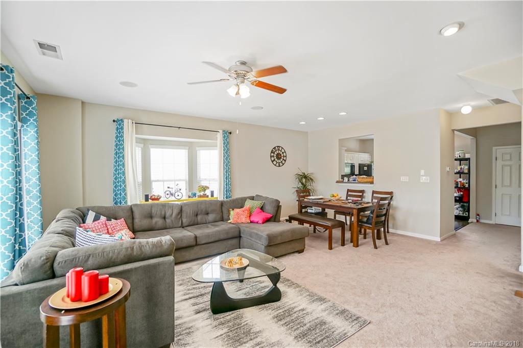10225 Garrett Grigg Road Charlotte, NC 28262 - Photo 6 of 30 a living room with furniture and a dining table with wooden floor