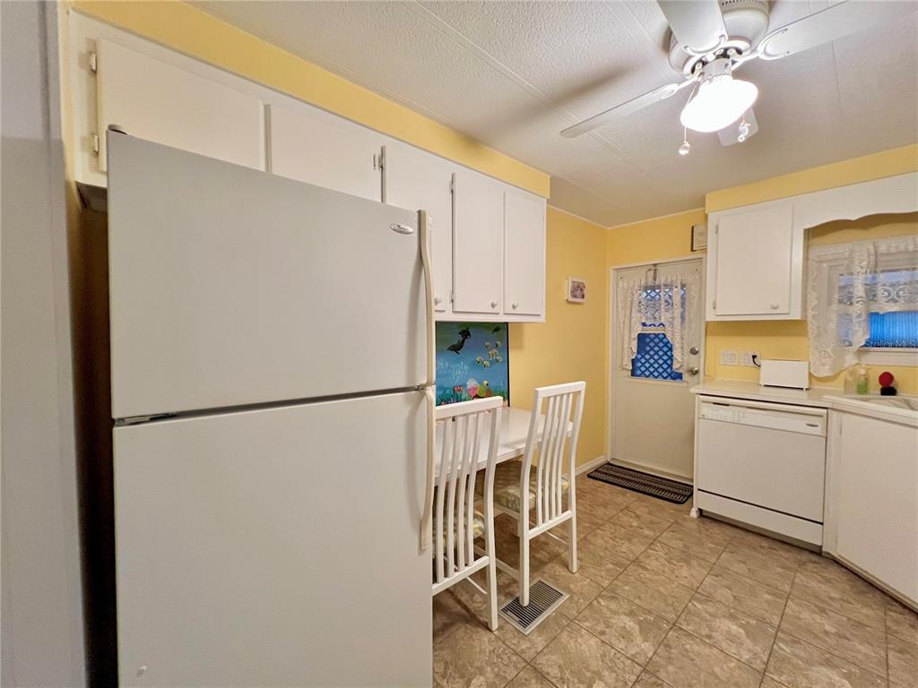 1100 South Belcher Road, Unit 190 Largo, FL 33771 - Photo 12 of 48 a white refrigerator freezer sitting in a kitchen with kitchen island and stainless steel appliances
