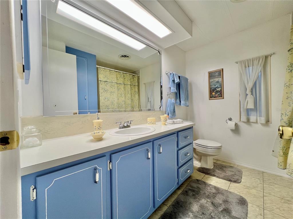 1100 South Belcher Road, Unit 190 Largo, FL 33771 - Photo 17 of 48 a bathroom with a granite countertop toilet sink and mirror