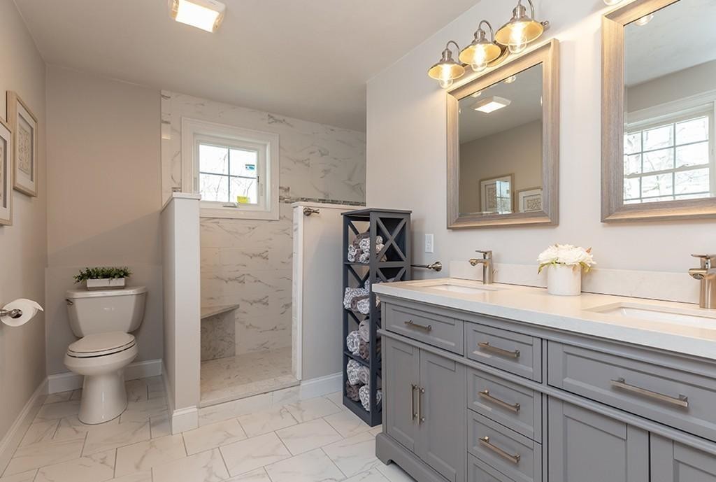 135 Sumner Street, Unit 1 Quincy, MA 02169 - Photo 9 of 13 a spacious bathroom with a granite countertop sink a toilet and a mirror