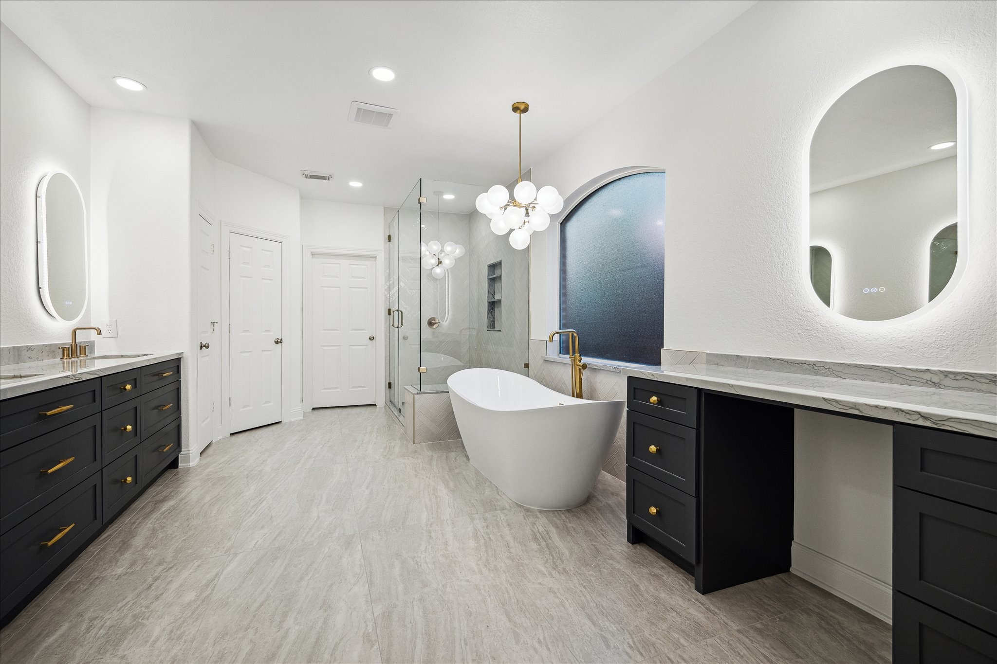 6211 Alameda Point Lane Houston, TX 77041 - Photo 22 of 50 Fully renovated spa-like primary ensuite featuring dual vanities, marble countertops, and gold hardware, backlit LED mirrors, and a freestanding soaking tub.