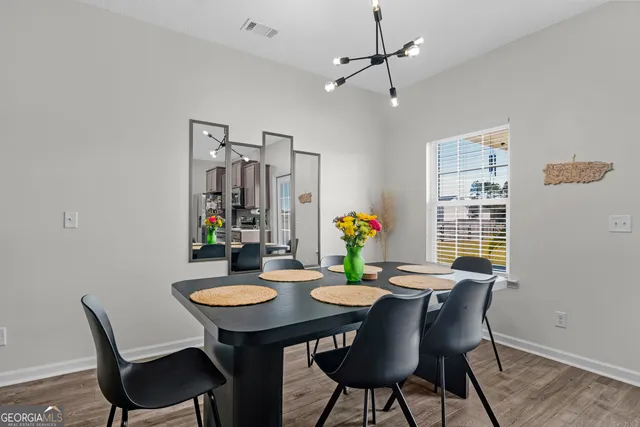 a living room with furniture kitchen view and a chandelier
