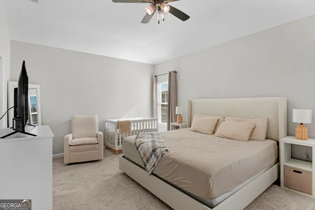 a bedroom with a bed and a flat tv screen on dresser