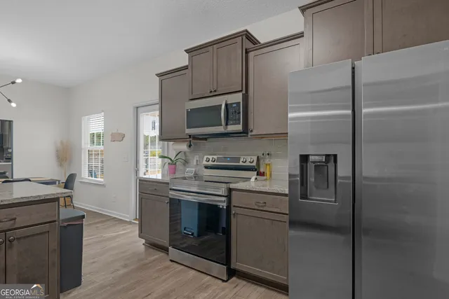 a kitchen with stainless steel appliances granite countertop a sink stove and microwave