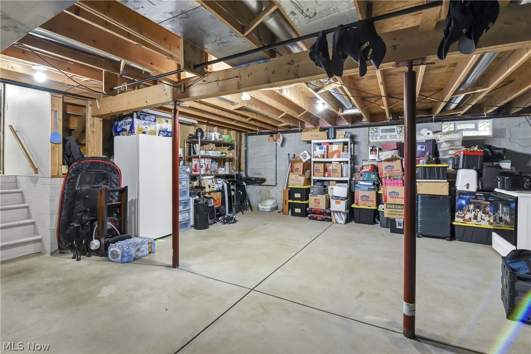 9550 Spencer Road Homerville, OH 44235 - Photo 27 of 50 Unfinished basement offering extensive open space, exposed wooden joists, concrete flooring, and ample storage potential