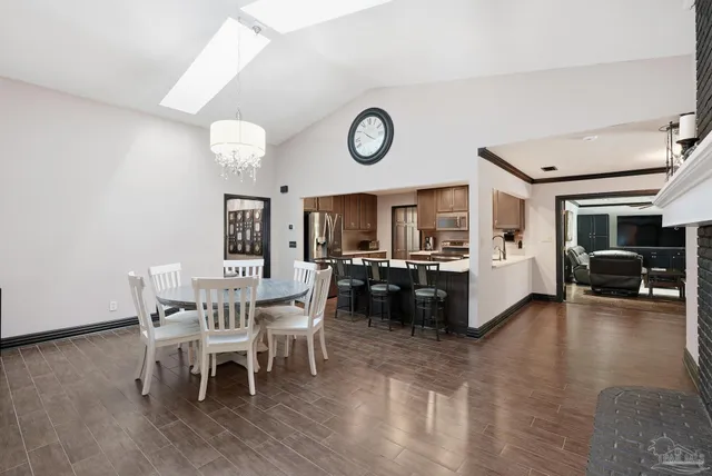 a view of a dining room and livingroom with furniture wooden floor a rug a flat screen tv
