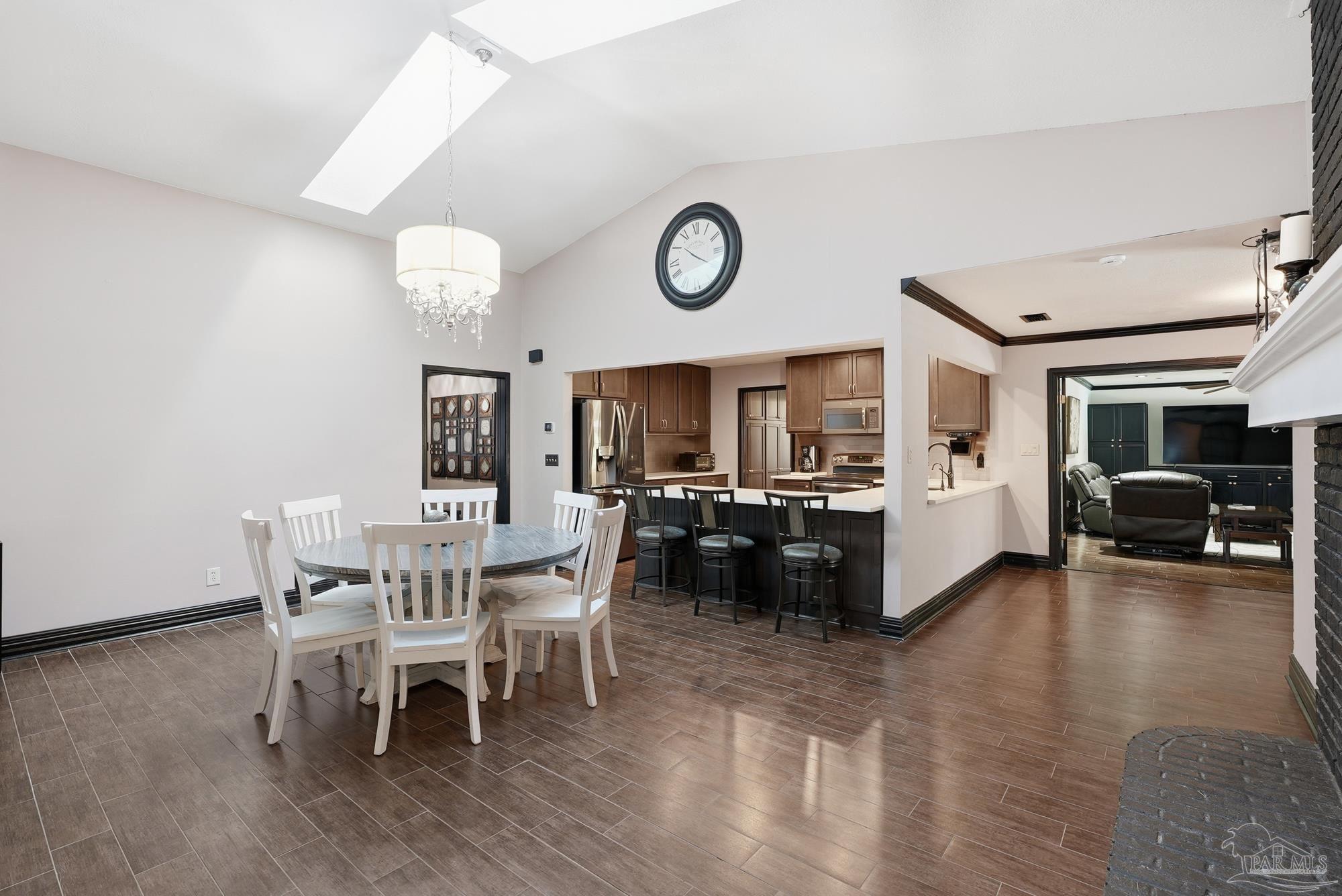 10145 Huntsman Path Pensacola, FL 32514 - Photo 12 of 47 a view of a dining room and livingroom with furniture wooden floor a rug a flat screen tv
