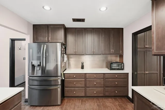 a kitchen with stainless steel appliances a refrigerator and wooden cabinets