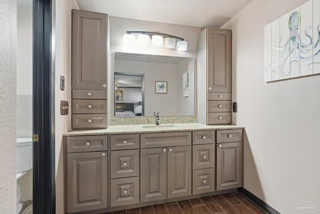 a spacious bathroom with a granite countertop double vanity sink a mirror and