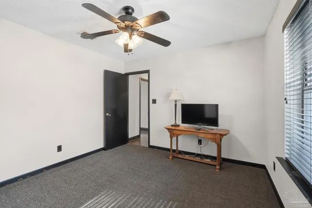 a view of a workspace with furniture and a window