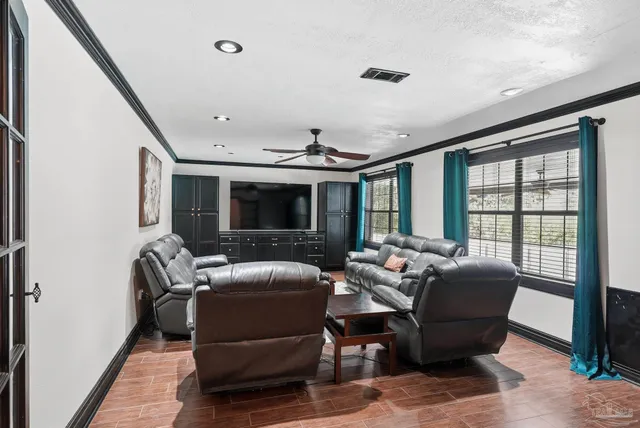 a living room with furniture ceiling fan and a flat screen tv
