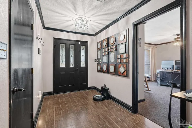 a view of a hallway with wooden floor and livingroom with furniture