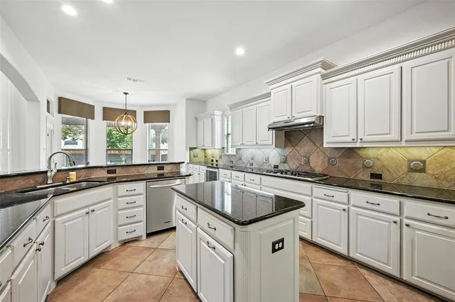 a kitchen with granite countertop white cabinets white stainless steel appliances with a sink and dishwasher
