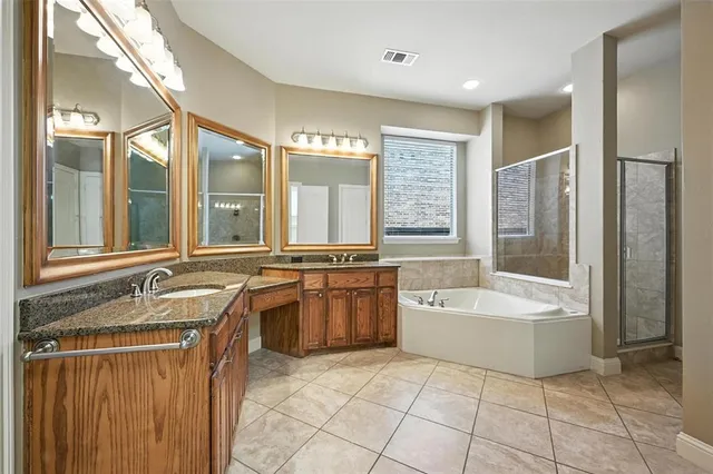 a spacious bathroom with a granite countertop tub sink and mirror