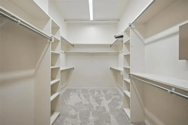 a view of walk in closet with empty racks