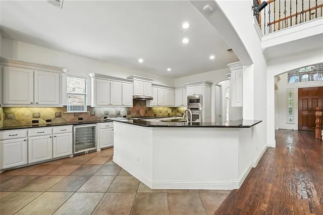 a kitchen with stainless steel appliances granite countertop a stove top oven a sink a counter space and cabinets