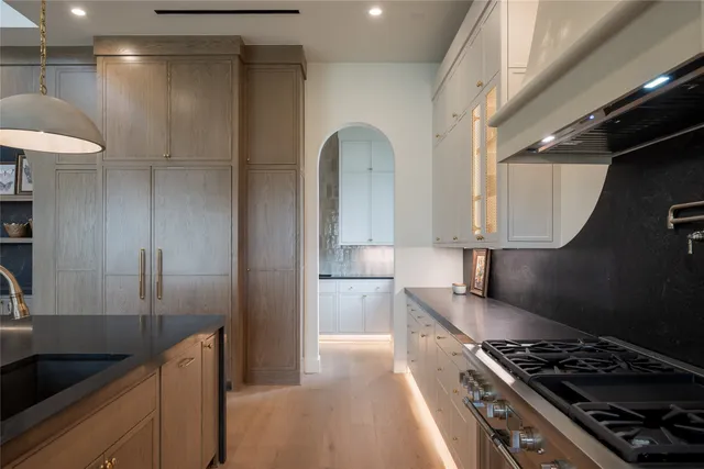 a kitchen with stainless steel appliances granite countertop white cabinets sink and window