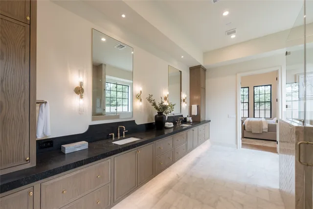 a large bathroom with a double vanity sink a large mirror and shower