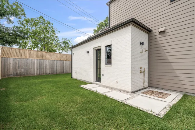 a view of a white house with a big yard and large tree