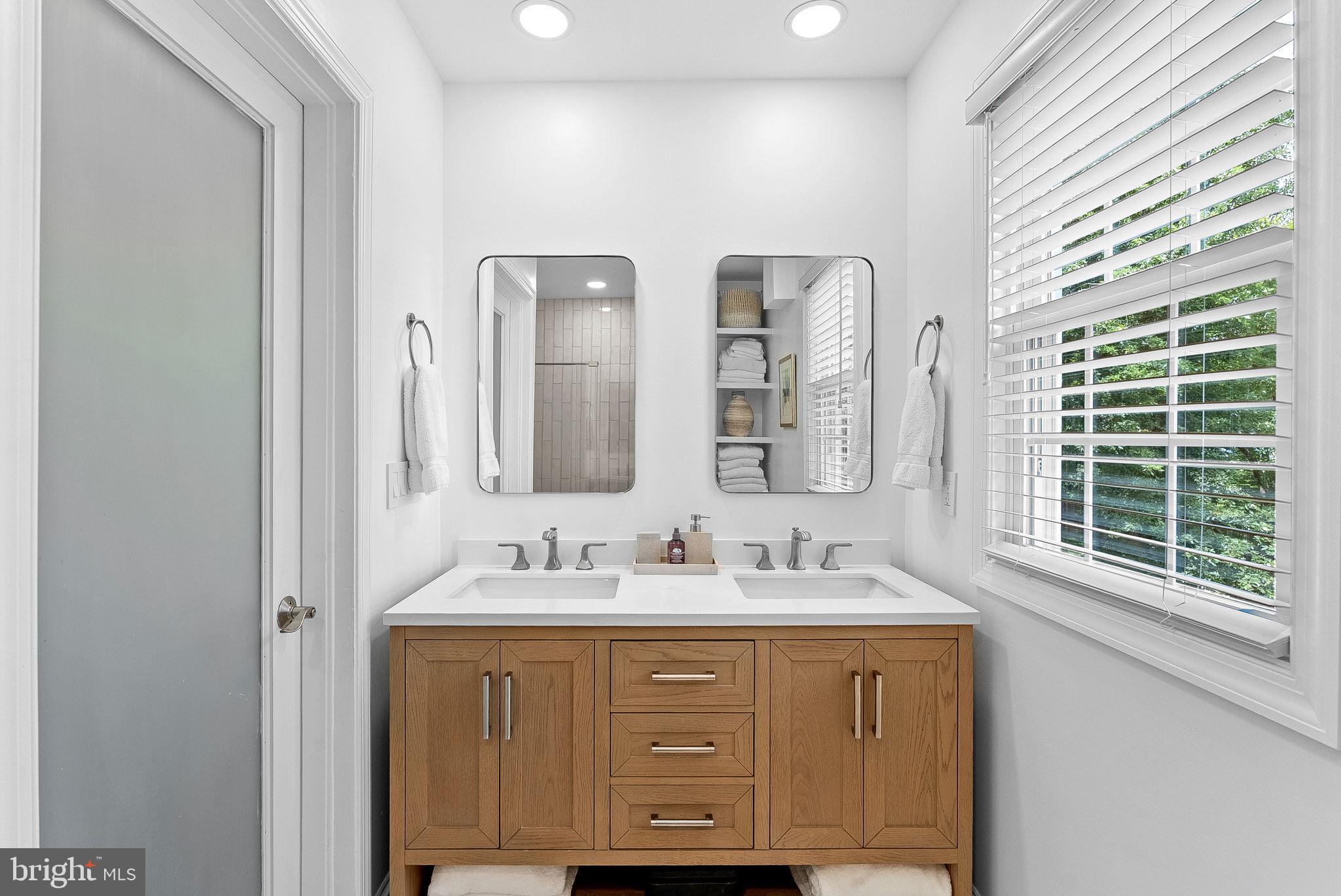 10313 Parkman Road Silver Spring, MD 20903 - Photo 33 of 61 a bathroom with a double vanity sink and a mirror