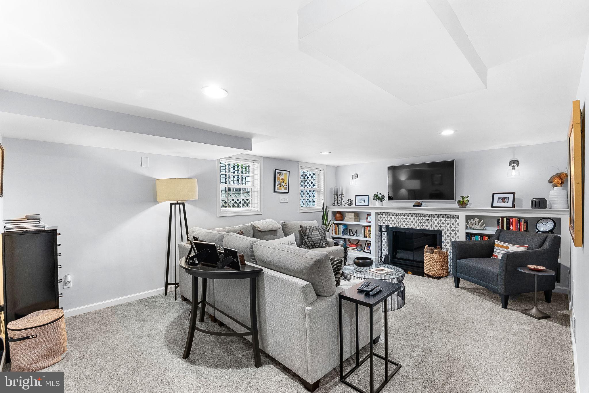 10313 Parkman Road Silver Spring, MD 20903 - Photo 36 of 61 a living room with furniture a fireplace and a flat screen tv