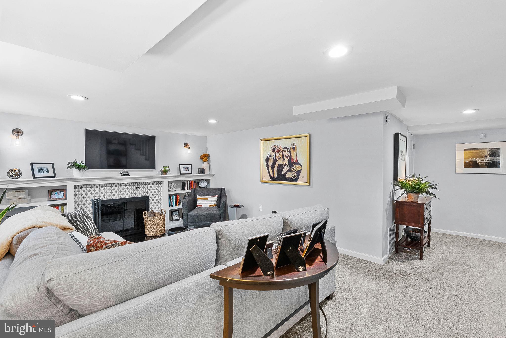 10313 Parkman Road Silver Spring, MD 20903 - Photo 38 of 61 a living room with furniture a fireplace and a flat screen tv