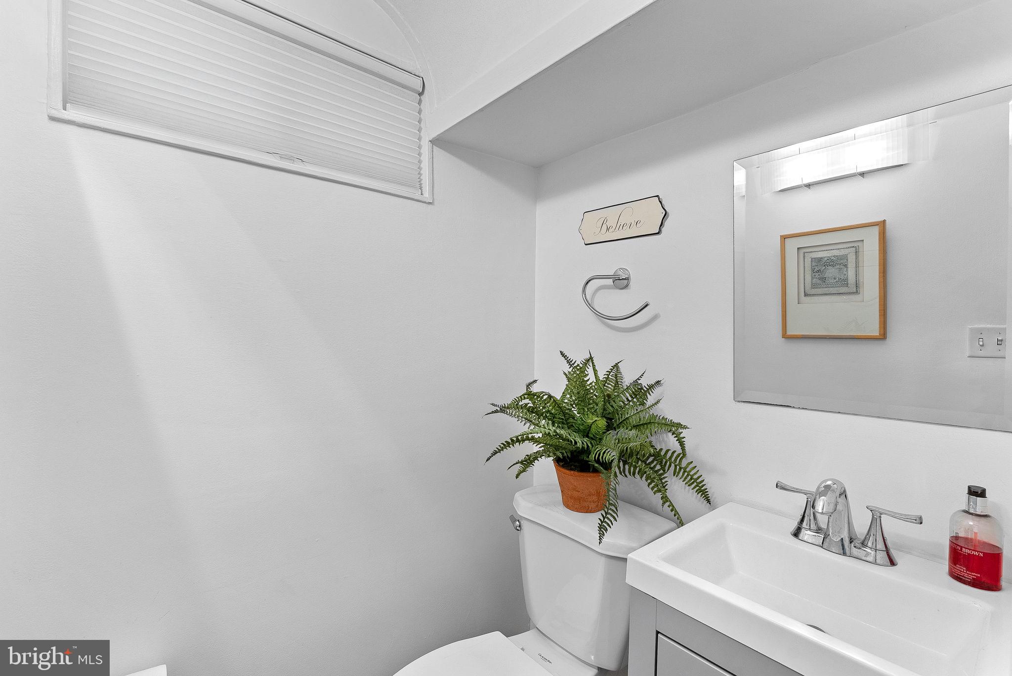 10313 Parkman Road Silver Spring, MD 20903 - Photo 42 of 61 a white toilet sitting next to a white sink and vanity