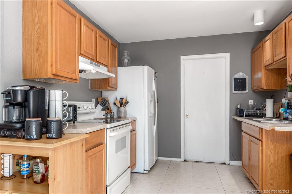 255 Southwest Homeland Road Port St. Lucie, FL 34953 - Photo 7 of 15 a kitchen with stainless steel appliances granite countertop a refrigerator a stove and a sink with cabinets
