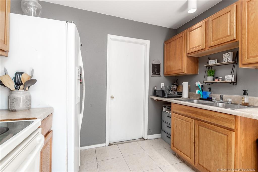 255 Southwest Homeland Road Port St. Lucie, FL 34953 - Photo 8 of 15 a kitchen with stainless steel appliances granite countertop a sink stove and cabinets