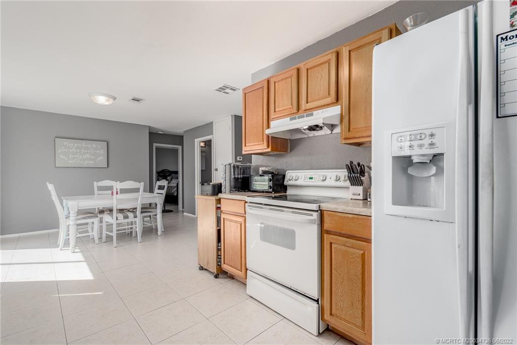 255 Southwest Homeland Road Port St. Lucie, FL 34953 - Photo 9 of 15 a kitchen with stainless steel appliances granite countertop a refrigerator and a stove top oven