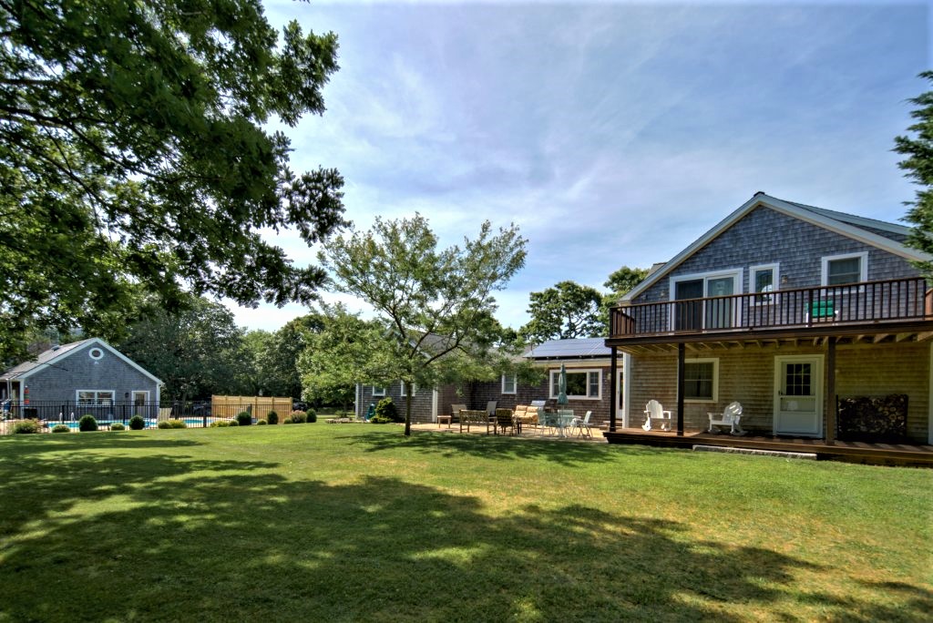 16 Meshacket Road Edgartown, MA 02539 - Photo 39 of 41 a front view of a house with a garden and trees