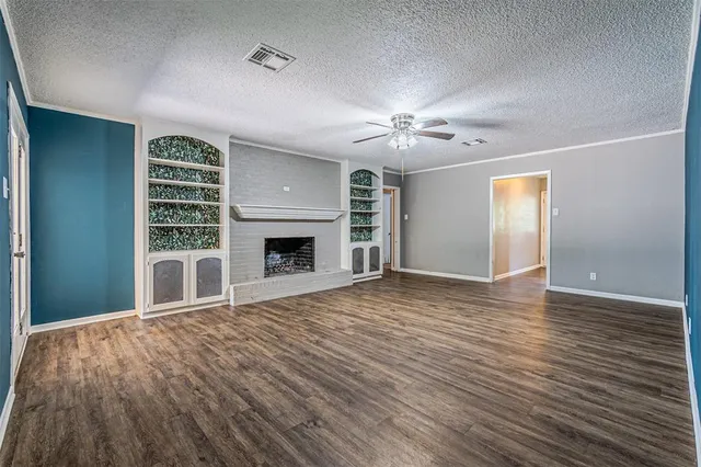 a view of an empty room with a fireplace and a window
