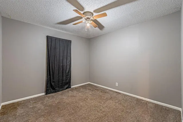 an empty room with closet and fan