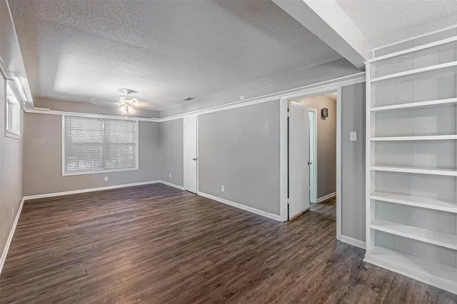 a view of empty room with wooden floor and window