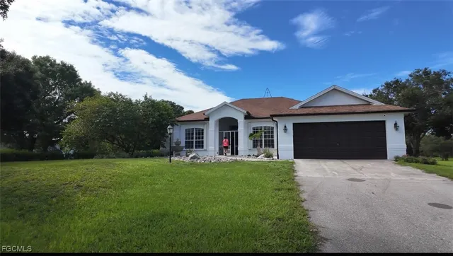 a front view of a house with a garden and yard