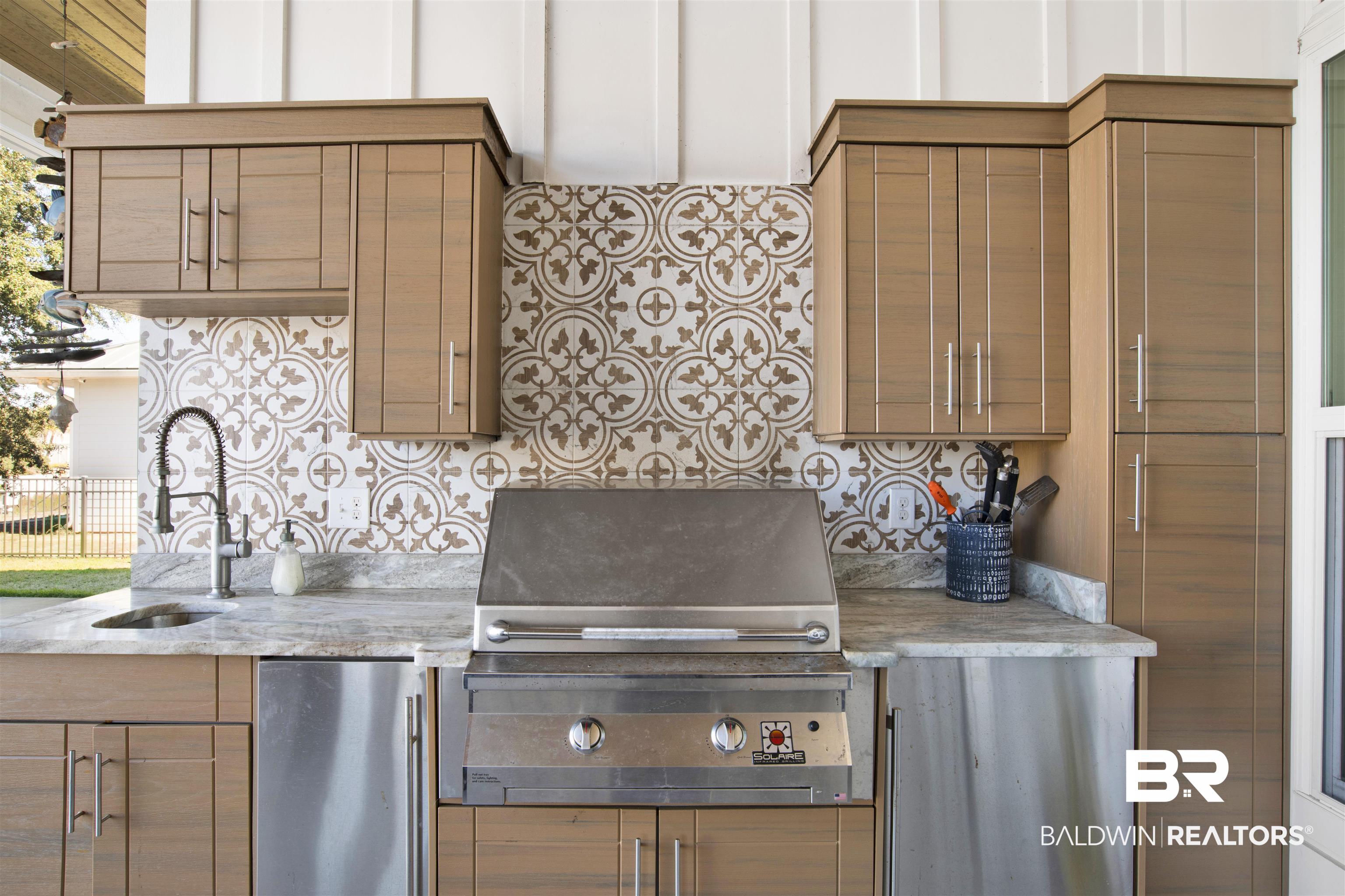 32937 River Road Orange Beach, AL 36561 - Photo 31 of 42 Kitchen featuring decorative backsplash, sink, and refrigerator