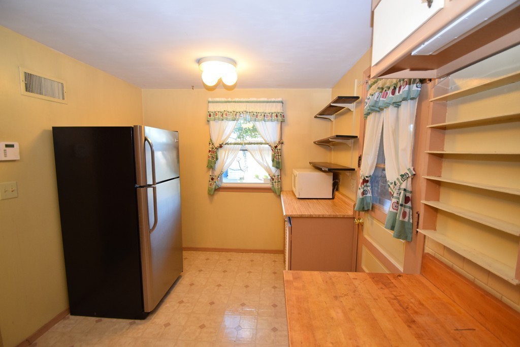 33 Clark Street, Unit A Randolph, MA 02368 - Photo 6 of 15 a kitchen with a refrigerator and a cabinets